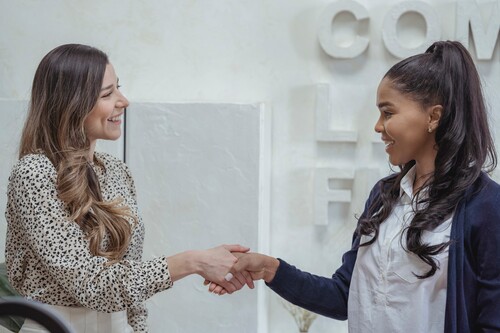 Two women shaking hands | Debt collector in Michigan