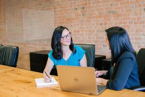 Two women working at a computer | Credit collection services Michigam