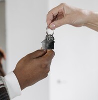 A person handing over their keys | debt collector Michigan