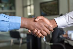 Two business people shaking hands | Collection agency Michigan