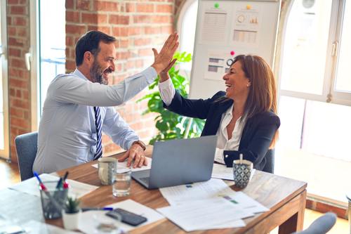 Two office workers high fiving | debt collector in Michigan